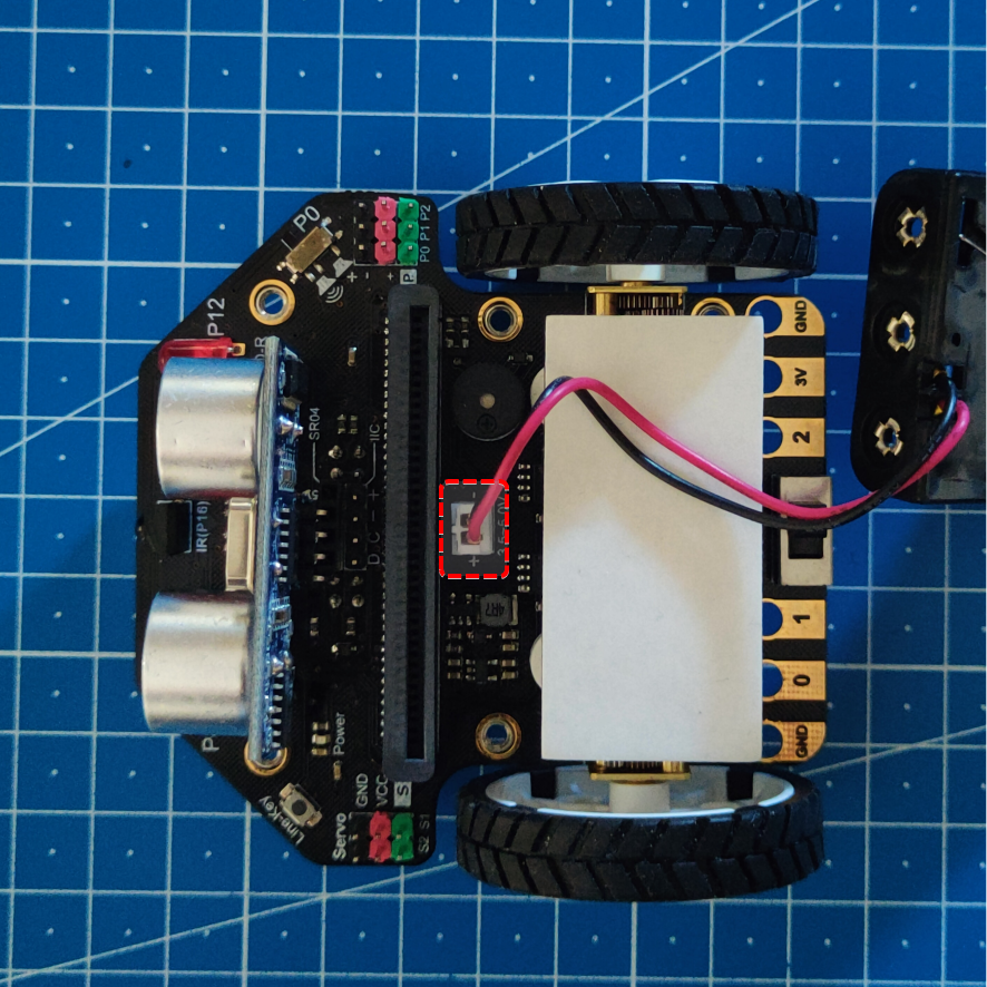 Imagen que muestra la conexión eléctrica del robot. Se muestra, mediante un recuadro rojo, el detalle de la conexión. El cable rojo debe ir al positivo y el cable negro al negativo.